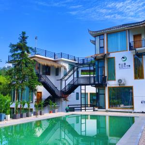 张家界Avatar Hilltop Manor B&B的酒店楼前有游泳池