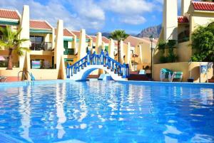 a blue bridge over a swimming pool in a resort at Mareverde Dream in Costa de Adeje