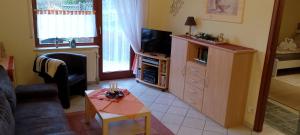 a living room with a couch and a tv at Zum Sauerländer Orketal in Medebach