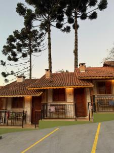 a building with two palm trees in front of it at Pousada Bosque in Monte Verde