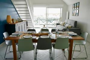 a dining table and chairs in a living room at L'appartement d'Hardelot, terrasse, parking, plage in Neufchâtel-Hardelot