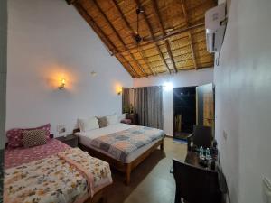 a bedroom with a bed and a desk and a bed sidx sidx sidx at Khushi's Cottage in Hampi