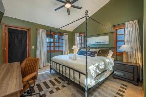 a bedroom with a canopy bed and a desk and a table at Mountain Views Hot Tub Family Room & Game Room in Swiss
