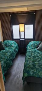 a bedroom with two beds and a window at Veluws Huisje in Apeldoorn