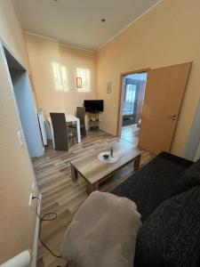 a room with a bed and a living room with a table at Ferienwohnung am Liebesgrund in Lüneburg