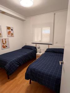 two beds in a room with blue sheets at Apartamento en Altea con vistas al mar in Altea