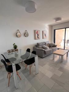 a living room with a glass table and chairs at Apartamento en Altea con vistas al mar in Altea