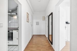 巴特菲尔伯尔MONTEUR - Unterkunft für bis zu 7 Personen in 61118 Bad Vilbel - FB10的走廊通往带白色墙壁和木地板的厨房 更多6张照片