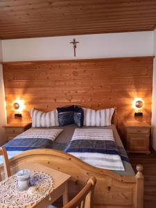 ein Schlafzimmer mit einem Bett und einem Kreuz an der Wand in der Unterkunft Sonne in Halblech