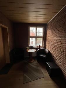 una camera con tavolo e muro di mattoni di Ferienwohnung am Liebesgrund a Lüneburg