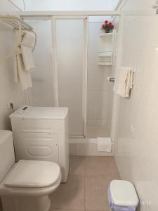 a white bathroom with a toilet and a shower at Comfortable bungalow in Santiago del Teide - 60 m² with balcony in Santiago del Teide