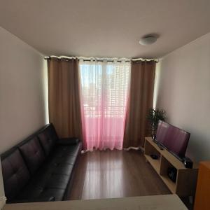 a living room with a couch and a television at Pauwla in Santiago