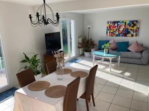 a living room with a table and a couch at Maison non fumeur - jardin 5 personnes proche des plages finistériennes in Guipavas