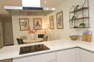 eine Küche mit einer weißen Arbeitsplatte und einem Tisch in der Unterkunft Fifty Steps from the beach! in Saint Merryn