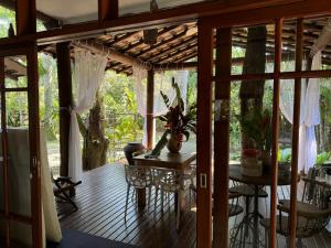 a screened in porch with a table and chairs at Casa da árvore em Paúba . in São Sebastião