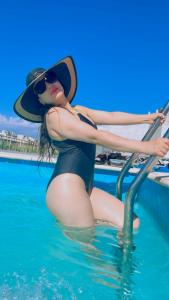 a woman in a hat sitting in the water at Pauwla in Santiago