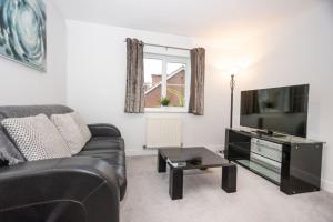 un salon avec un canapé et une télévision à écran plat dans l'établissement Doulton House - 2 Bedroom Sleeps 5 Wifi Parking, à Wharton