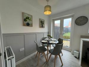 une salle à manger avec une table, des chaises et une horloge dans l'établissement Bolehyde House, Sleeps 6, 3 Bedrooms, North Swindon location, Parking, à Swindon 14 autres photos