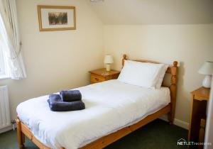 a bedroom with a bed with a blue towel on it at Stone Hall Mill Cottage - Tranquil Countryside Haven in Pembrokeshire in Saint Lawrence