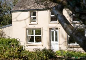 a white house with a white door and windows at Stone Hall Mill Cottage - Tranquil Countryside Haven in Pembrokeshire in Saint Lawrence