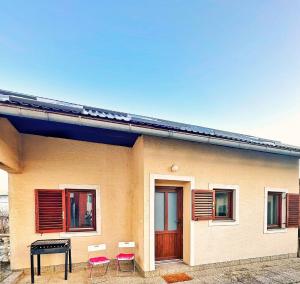a house with chairs and a table in front of it at Bajkoviti kutak 2 in Ogulin