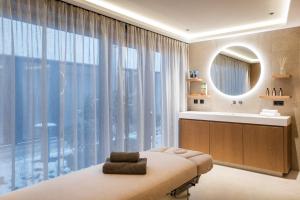 迈尔霍芬Neuhaus Zillertal Resort的配有床、水槽和镜子的浴室
