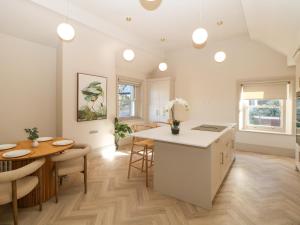 a kitchen and dining room with a table and a counter at Chatsworth Suite in Buxton