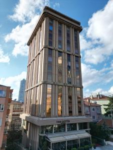 a tall building with glass windows in a city at The Cettia Istanbul in Istanbul