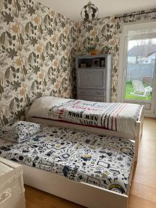 two twin beds in a bedroom with a wall at Le Rivage, Maison avec jardin proche de la mer in Saint-Aubin-sur-Mer