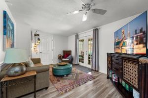 a living room with a couch and a tv at Luxury Zen Den with heated pool just off Siesta Key in Sarasota