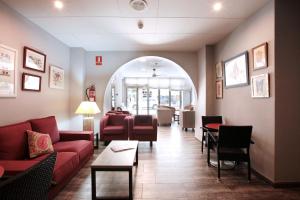 a waiting room with red couches and chairs at Hotel Marblau Tossa in Tossa de Mar
