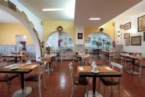 a restaurant with tables and chairs in a room at Hotel Marblau Tossa in Tossa de Mar