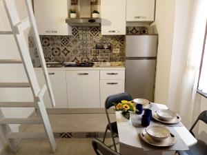 a small kitchen with a table and a refrigerator at La Casa Rossa in Stintino