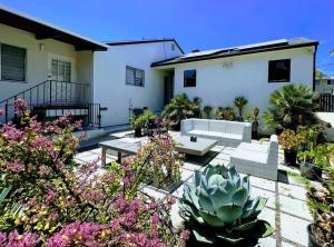 un patio con sofás y plantas frente a una casa en Bright 2-BR Home Near LAX with Shared Yard - SH2-LAD, en Los Ángeles