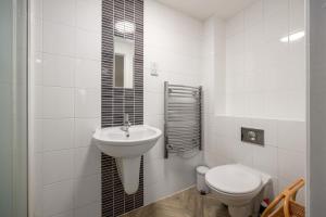 a white bathroom with a sink and a toilet at Modern Flat, Oxford city centre in Oxford