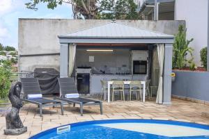 cenador con cocina, mesa y sillas en Villa ÉVASION, en Le Gosier