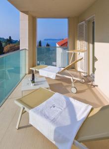a balcony with a white shirt on a table at Dubrovnik Luxury Residence – L’Orangerie in Dubrovnik