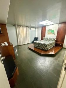 a room with a bed and a chair in it at Minas Palace Hotel in Passos +18 photos