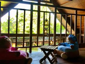 two teddy bears sitting on a bench in a room at Lagoon Bungalows Bali in Nusa Dua