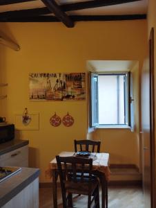 una cucina con tavolo, sedie e finestra di La Casa di Patty a Sutri