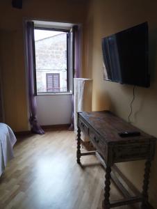 una camera con tavolo in legno e TV a parete di La Casa di Patty a Sutri Altre 22 foto
