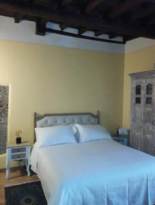 una camera da letto con un letto grande con lenzuola bianche di La Casa di Patty a Sutri