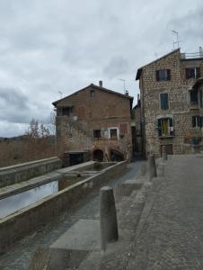 un vecchio edificio in pietra vicino a un canale in una città di La Casa di Patty a Sutri