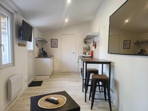 eine kleine Küche mit Tisch und Stühlen in einem Zimmer in der Unterkunft Petit studio proche centre-ville in Vitré