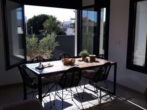 Una mesa de comedor con sillas y una gran ventana. en CASA CALMA - Townhouse, en San Juan de los Terreros