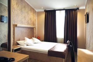 Habitación de hotel con cama y ventana en Rondo Hotel, en Tiflis