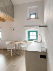 a kitchen with a sink and a table with chairs at Lagom Home Vipavski Križ in Ajdovščina +35 photos