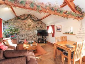 a living room with a table and a dining room at Sonya's Cottage in Anthorn