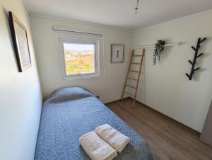 a bedroom with a bed with a blue blanket and a window at Hermoso y nuevo departamento con gran vista - Papudo in Papudo +18 photos