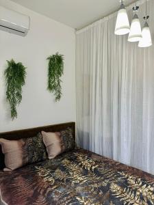 1 dormitorio con 1 cama con plantas en la pared en Parrot Chic Apartment, en Bar 12 fotos más